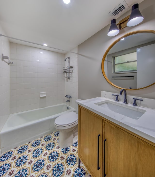 full bathroom with tiled shower / bath, tile patterned floors, toilet, and vanity