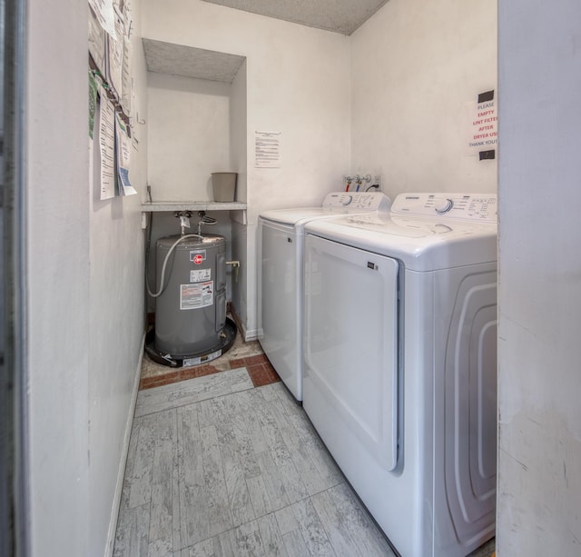 laundry room with water heater and washing machine and clothes dryer