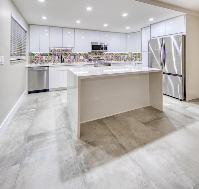 kitchen with backsplash, sink, white cabinets, and appliances with stainless steel finishes