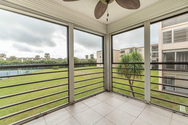 unfurnished sunroom with a water view and ceiling fan