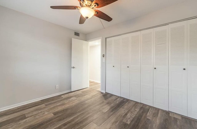 unfurnished bedroom featuring dark wood-type flooring, ceiling fan, and a closet