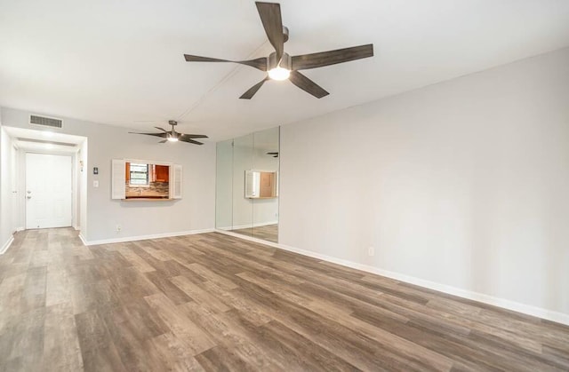 unfurnished living room with wood-type flooring and ceiling fan