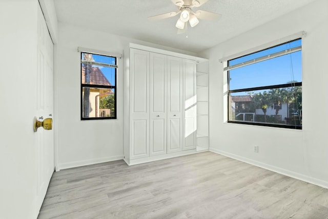 unfurnished bedroom with ceiling fan, light hardwood / wood-style floors, and a textured ceiling