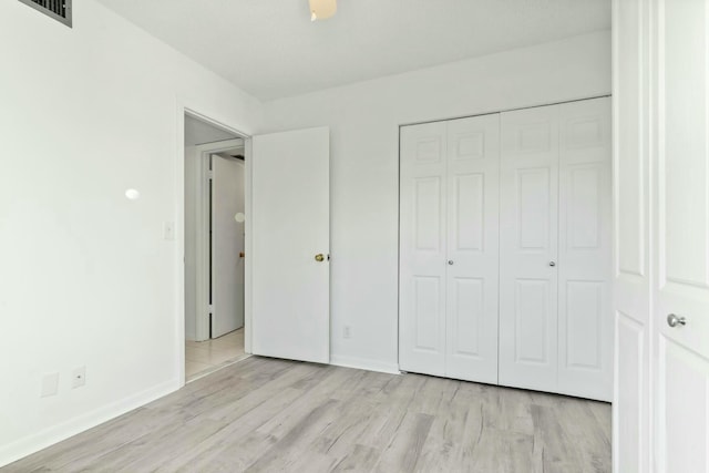 unfurnished bedroom featuring light hardwood / wood-style flooring and a closet