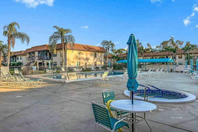 view of swimming pool featuring a patio area and a hot tub