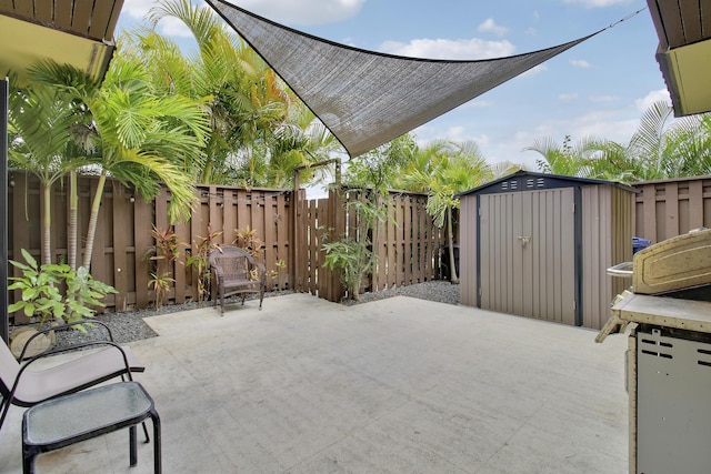 view of patio / terrace with a shed, a fenced backyard, and an outbuilding