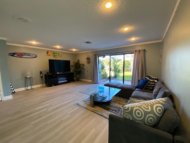 living room featuring ornamental molding, hardwood / wood-style floors, and a textured ceiling