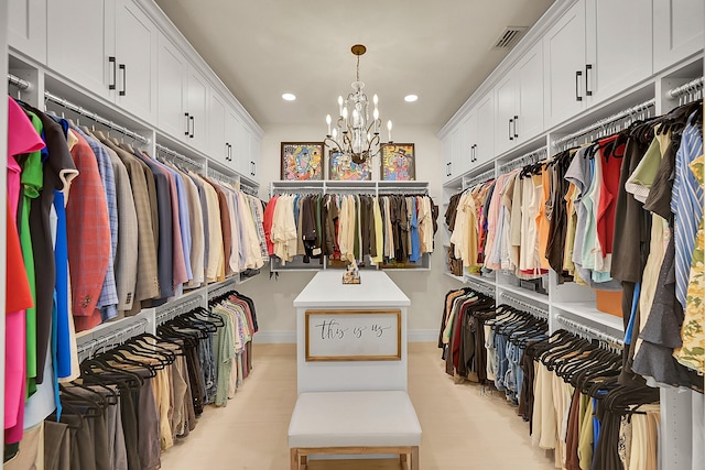 walk in closet with a chandelier