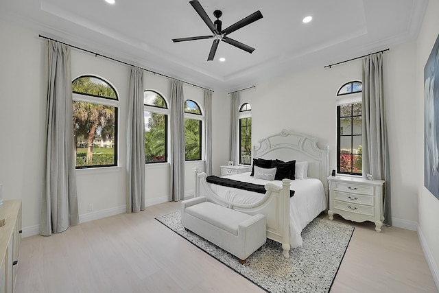 bedroom with a raised ceiling and multiple windows