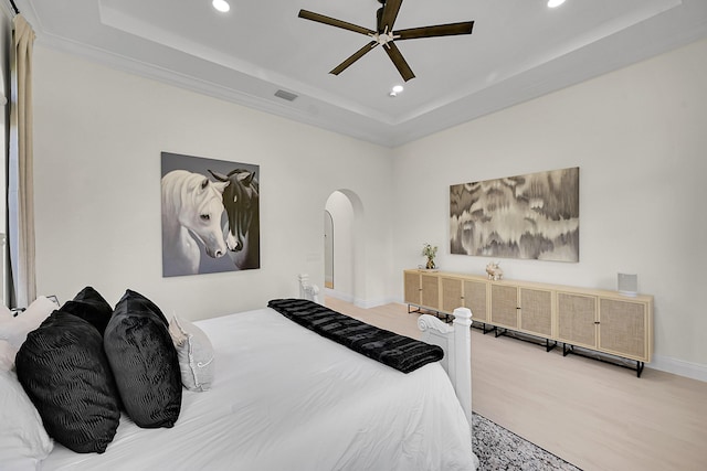 bedroom with ceiling fan and a tray ceiling