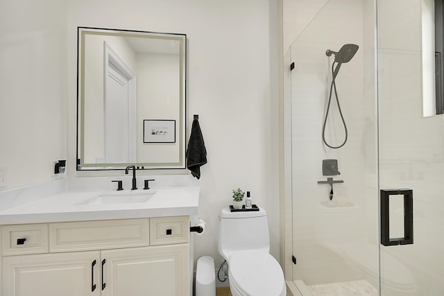 bathroom with vanity, a shower with door, and toilet