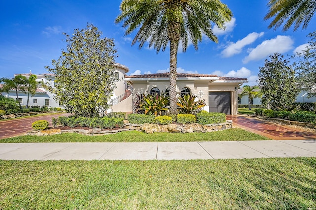 mediterranean / spanish-style house with a garage and a front yard