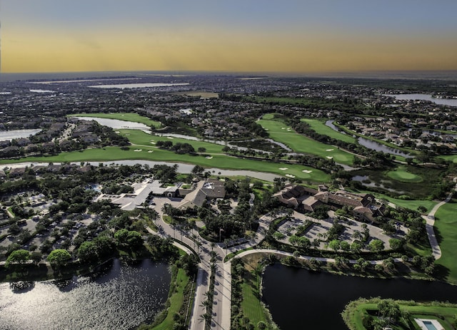 aerial view at dusk featuring a water view