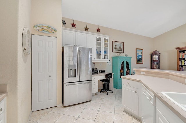 kitchen with light tile patterned floors, sink, white dishwasher, white cabinets, and stainless steel fridge with ice dispenser