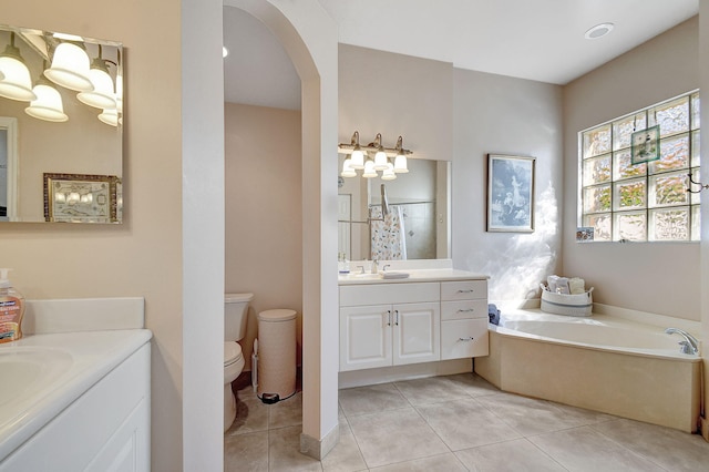 bathroom featuring vanity, a bathing tub, tile patterned floors, and toilet