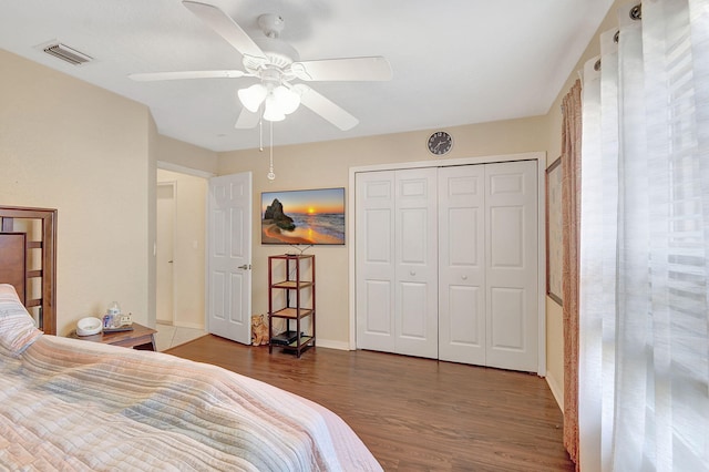 bedroom featuring ceiling fan, dark hardwood / wood-style flooring, and a closet