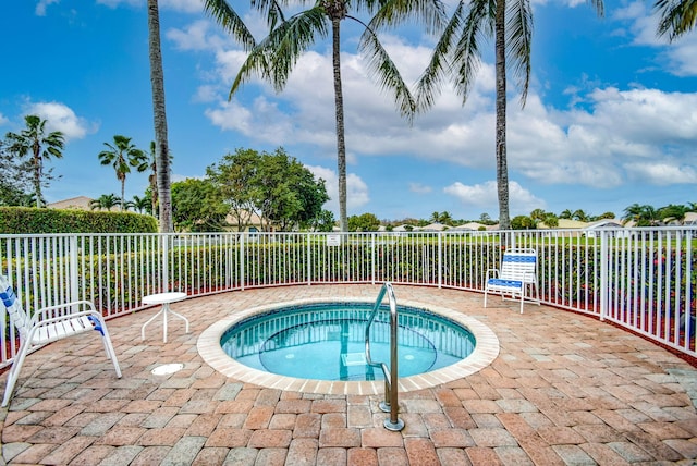 view of swimming pool featuring a hot tub and a patio