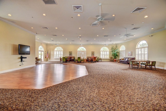 interior space with ceiling fan, ornamental molding, and carpet floors