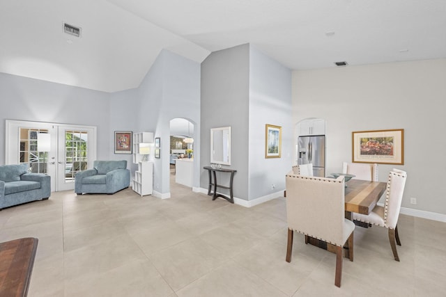 dining room with visible vents, high vaulted ceiling, french doors, arched walkways, and baseboards