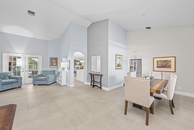 sitting room featuring light tile patterned flooring, french doors, baseboards, and high vaulted ceiling