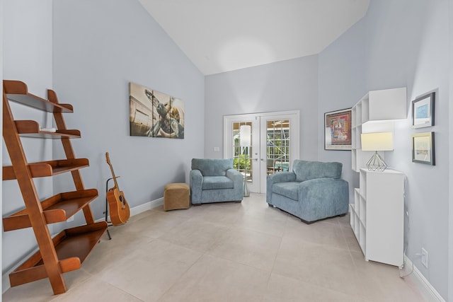 sitting room with light tile patterned floors, high vaulted ceiling, and french doors