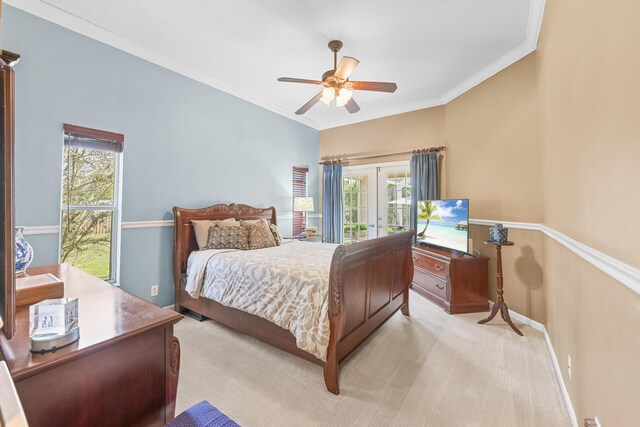 carpeted bedroom with multiple windows, ornamental molding, french doors, and ceiling fan