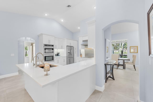 kitchen with sink, white cabinets, light tile patterned floors, kitchen peninsula, and stainless steel appliances