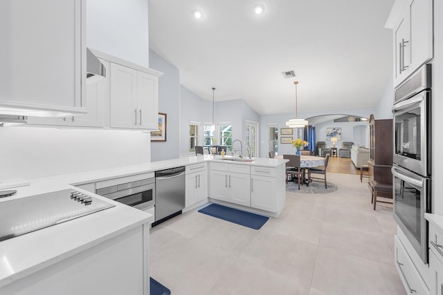 kitchen with visible vents, a sink, stainless steel appliances, arched walkways, and light countertops