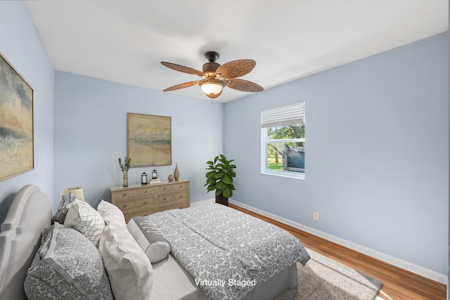 bedroom featuring a ceiling fan, wood finished floors, and baseboards