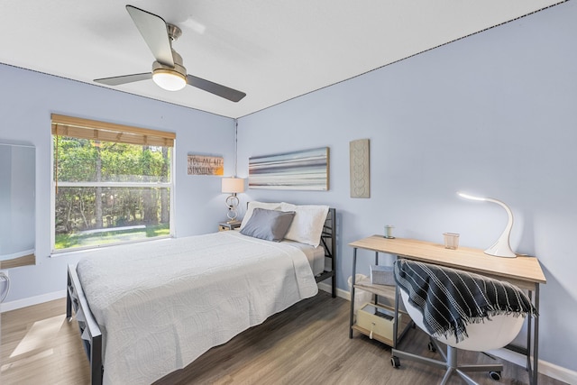 bedroom with ceiling fan, baseboards, and wood finished floors