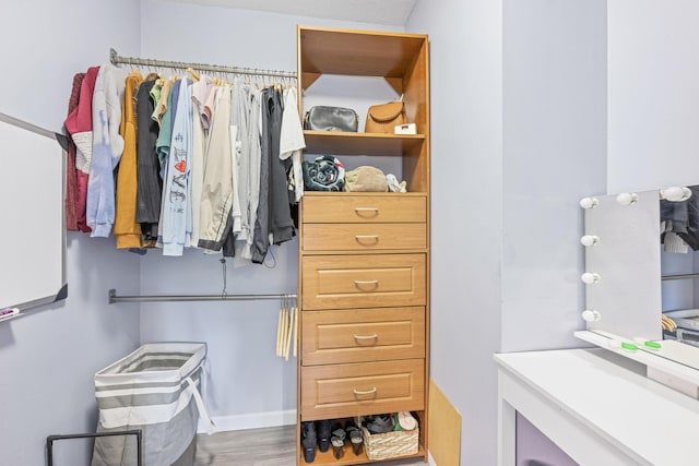 walk in closet with wood finished floors