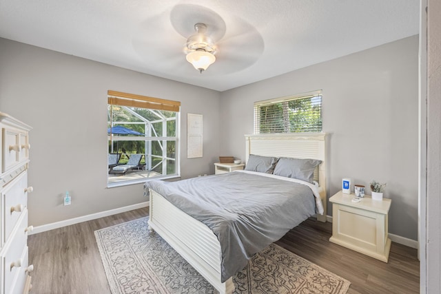 bedroom with baseboards, wood finished floors, and a ceiling fan