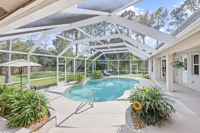 outdoor pool with a patio area, glass enclosure, a yard, and fence