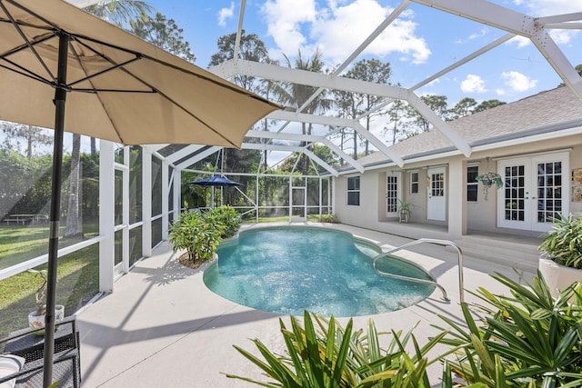 pool with glass enclosure, a patio area, and french doors