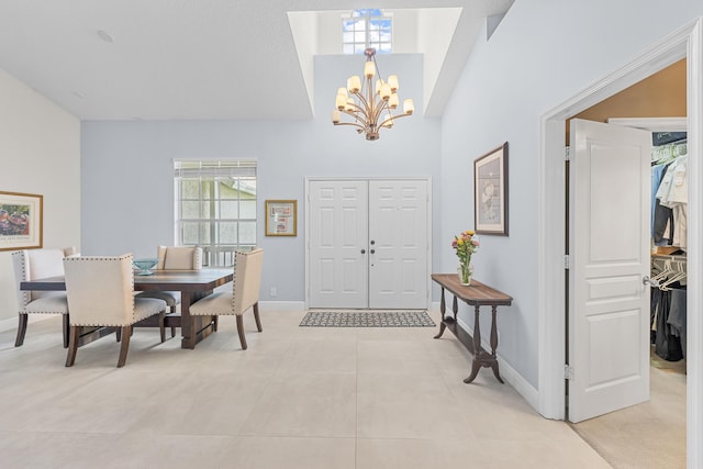 dining area with light tile patterned floors, a notable chandelier, and baseboards