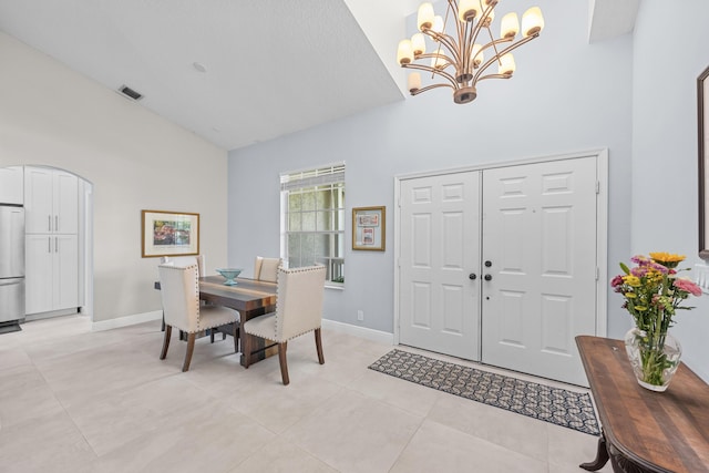 dining area with light tile patterned floors, visible vents, baseboards, high vaulted ceiling, and arched walkways