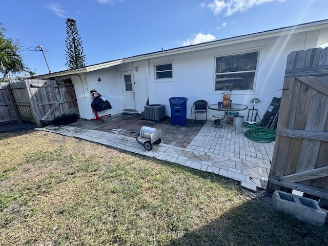 back of house with a yard, central AC unit, and a patio area