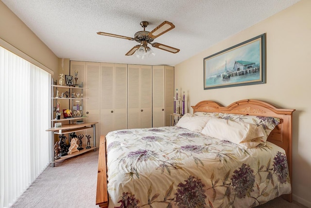 carpeted bedroom featuring ceiling fan and a textured ceiling