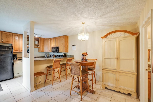 kitchen featuring black appliances, kitchen peninsula, a textured ceiling, and a kitchen bar