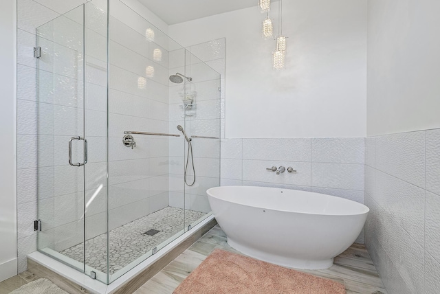 330 Franklin Rd, West Palm Beach, FL 33405 - bathroom featuring a shower stall, a freestanding tub, tile walls, and wainscoting