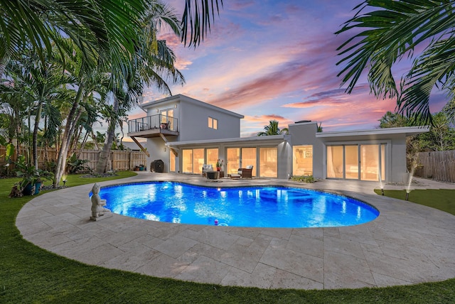 pool at dusk with a patio