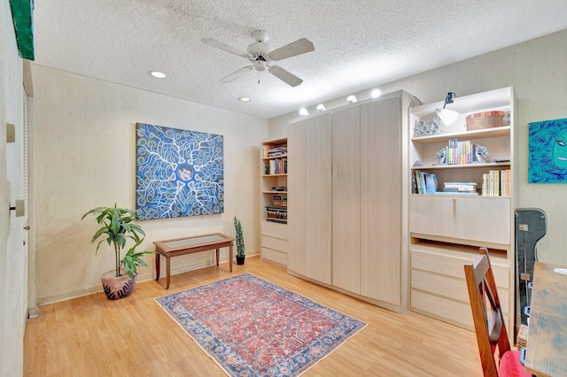 office space with ceiling fan, light hardwood / wood-style flooring, and a textured ceiling