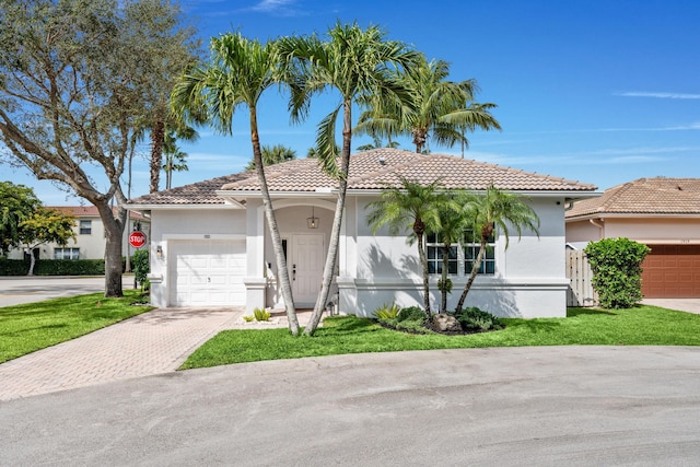 mediterranean / spanish-style home with a garage and a front yard