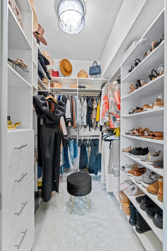 walk in closet featuring a chandelier