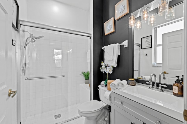 bathroom with vanity, a shower with door, and toilet