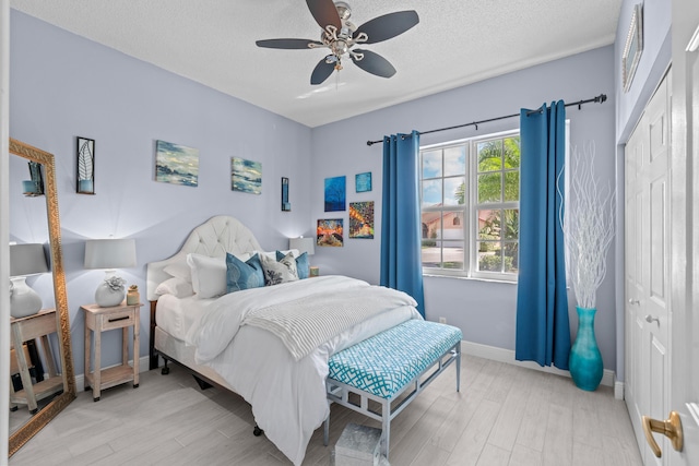 bedroom featuring ceiling fan, a textured ceiling, and light wood-type flooring