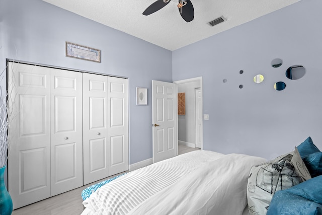 bedroom with ceiling fan, a textured ceiling, a closet, and light wood-type flooring