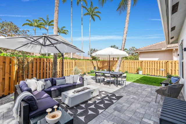 view of patio with an outdoor living space with a fire pit