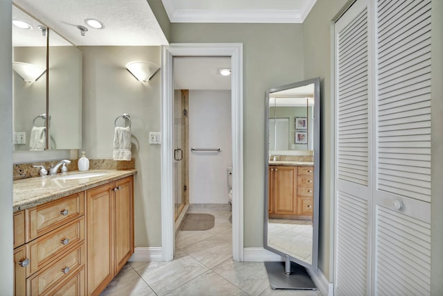 bathroom with ornamental molding, vanity, toilet, and a shower with door