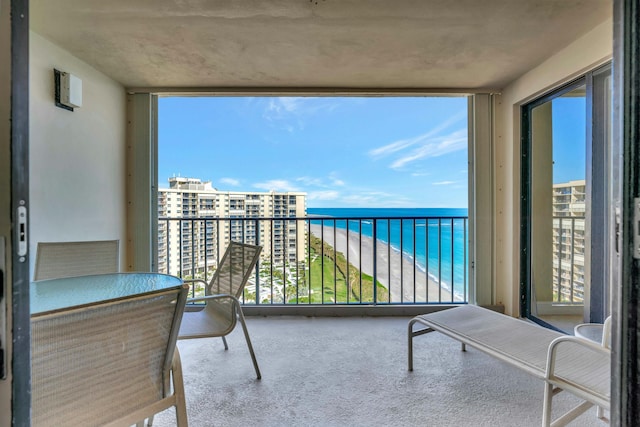 balcony with a water view and a beach view